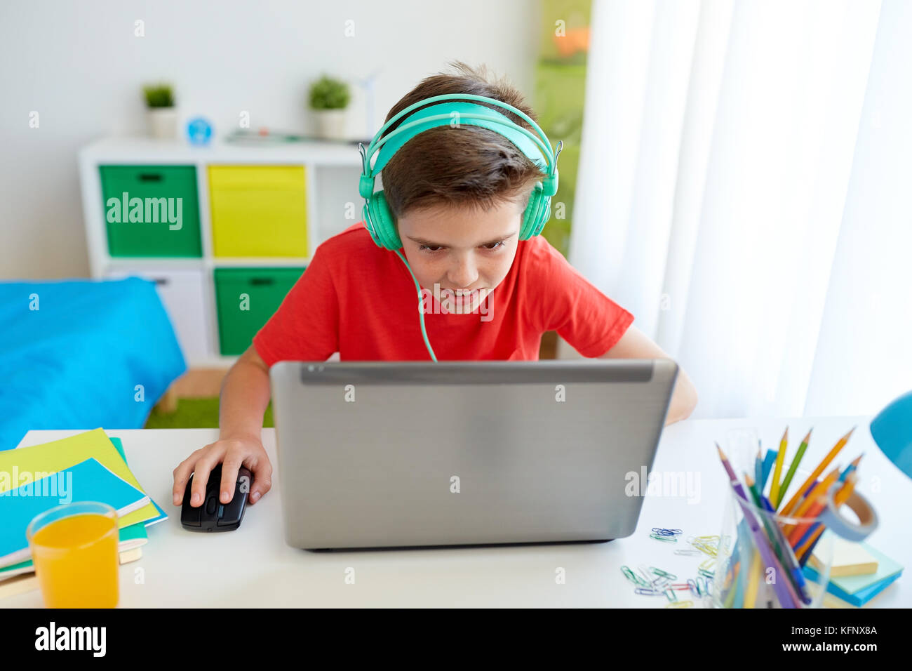 Junge in Kopfhörer spielen video game auf Laptop Stockfoto