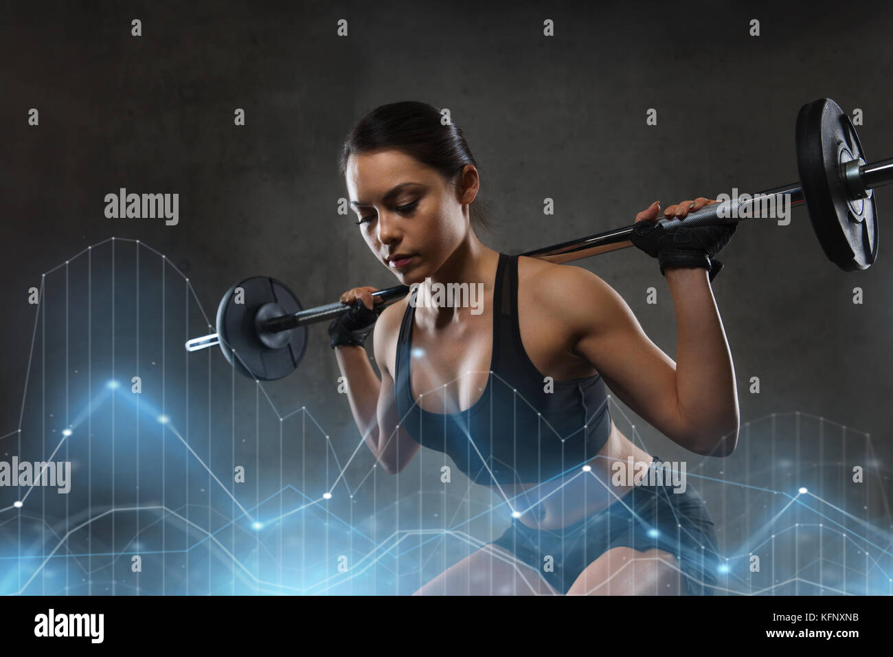 Junge Frau flexing Muskeln mit Barbell in der Turnhalle Stockfoto