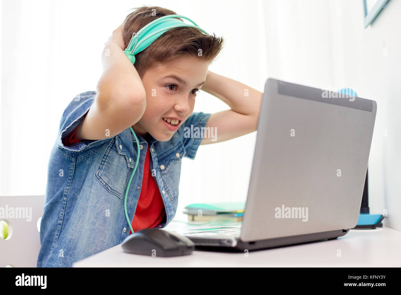 Junge in Kopfhörer spielen video game auf Laptop Stockfoto