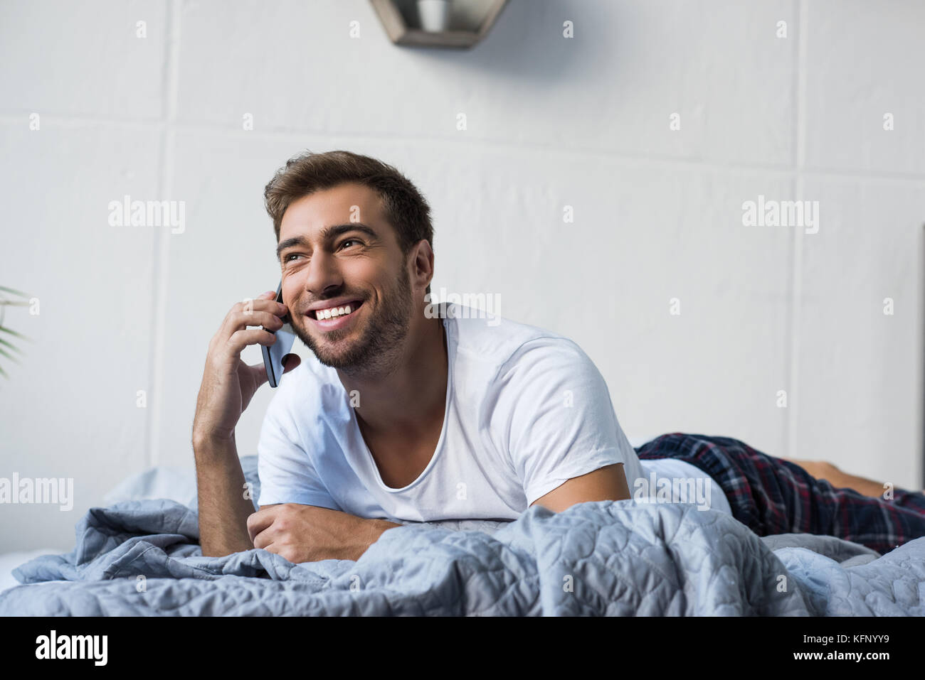 Mann im Bett am Telefon sprechen Stockfoto