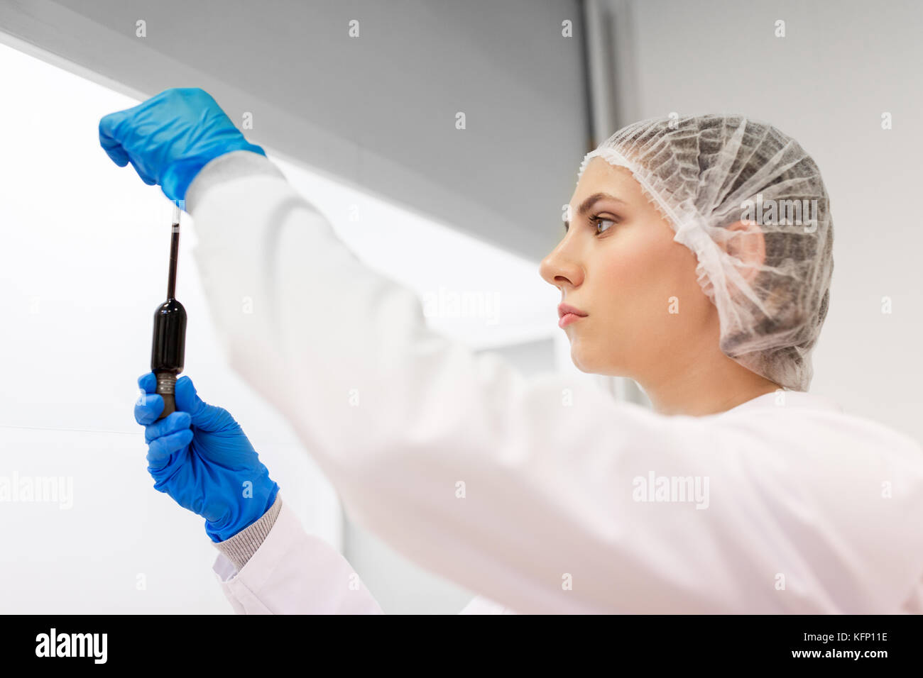 Frau mit Schwefelsäure in Dropper im Labor Stockfoto