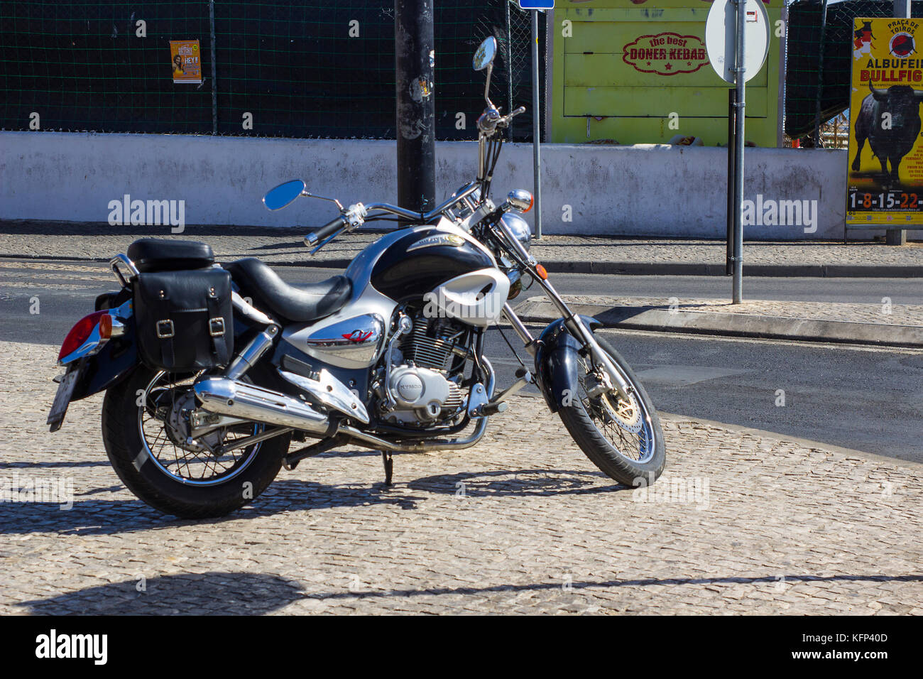 Ein modernes Harley Davidson Motorrad mit hochglanzpolierten Chromteilen auf einer Kopfsteinpflasterstraße in Albuderia in Portugal geparkt Stockfoto