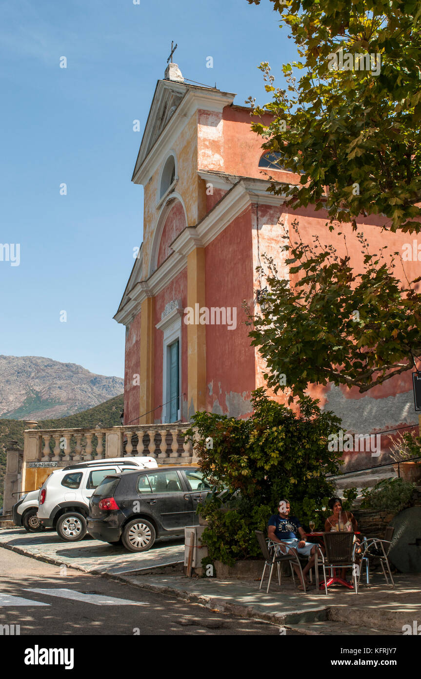 Korsika: Sitzplätze im Freien in der Nähe der Rosa gemalte Kirche des hl. Julie (xvi Jahrhundert) in Nonza, einem berühmten Dorf an der Westküste des Cap Corse Stockfoto