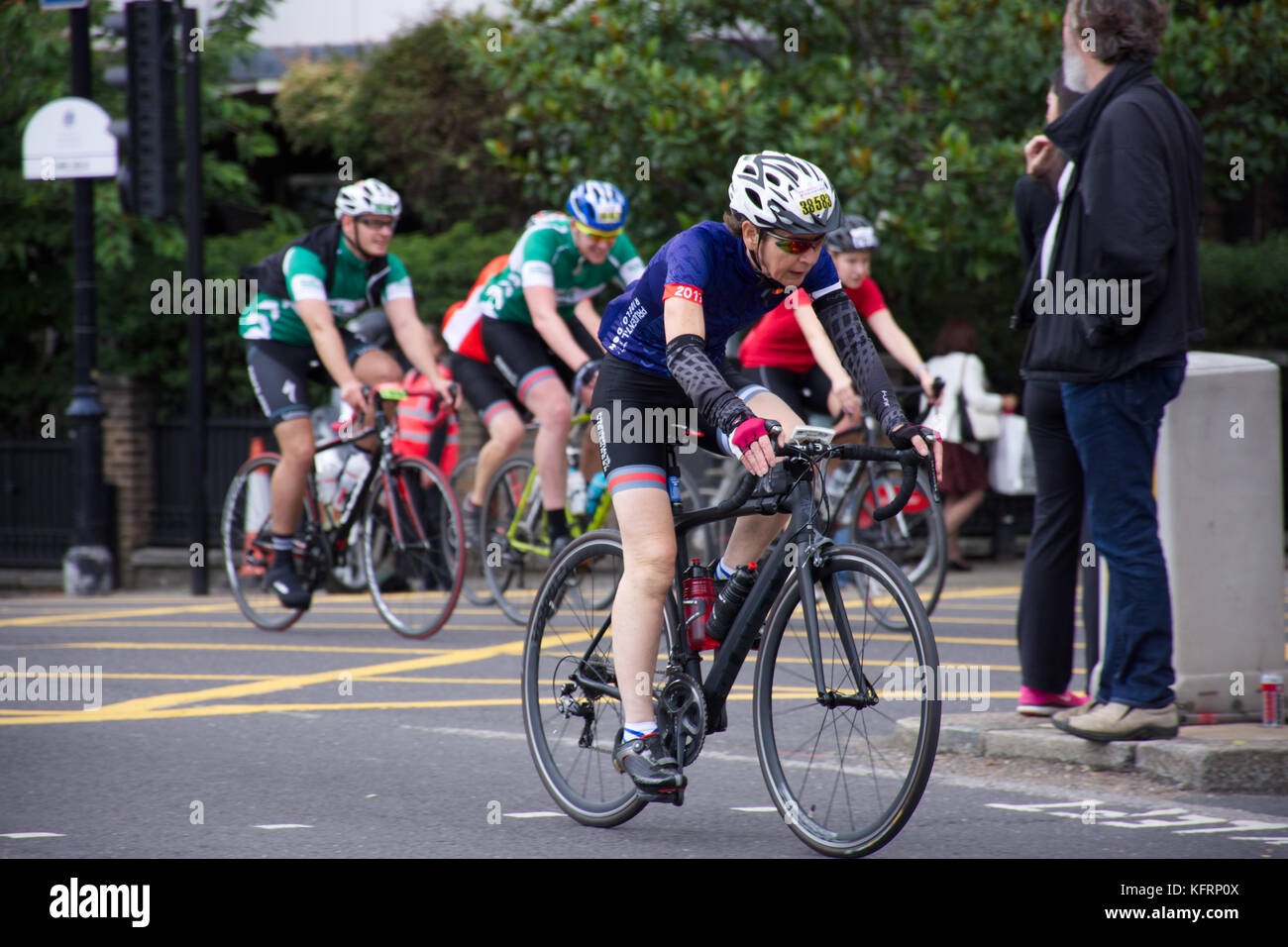 Frau mittleren Alters, die in den weißen Helm, schwarz Fahrrad auf jährlichen London prudential Radrennen. London, Vereinigtes Königreich, Sommer 2017. Stockfoto