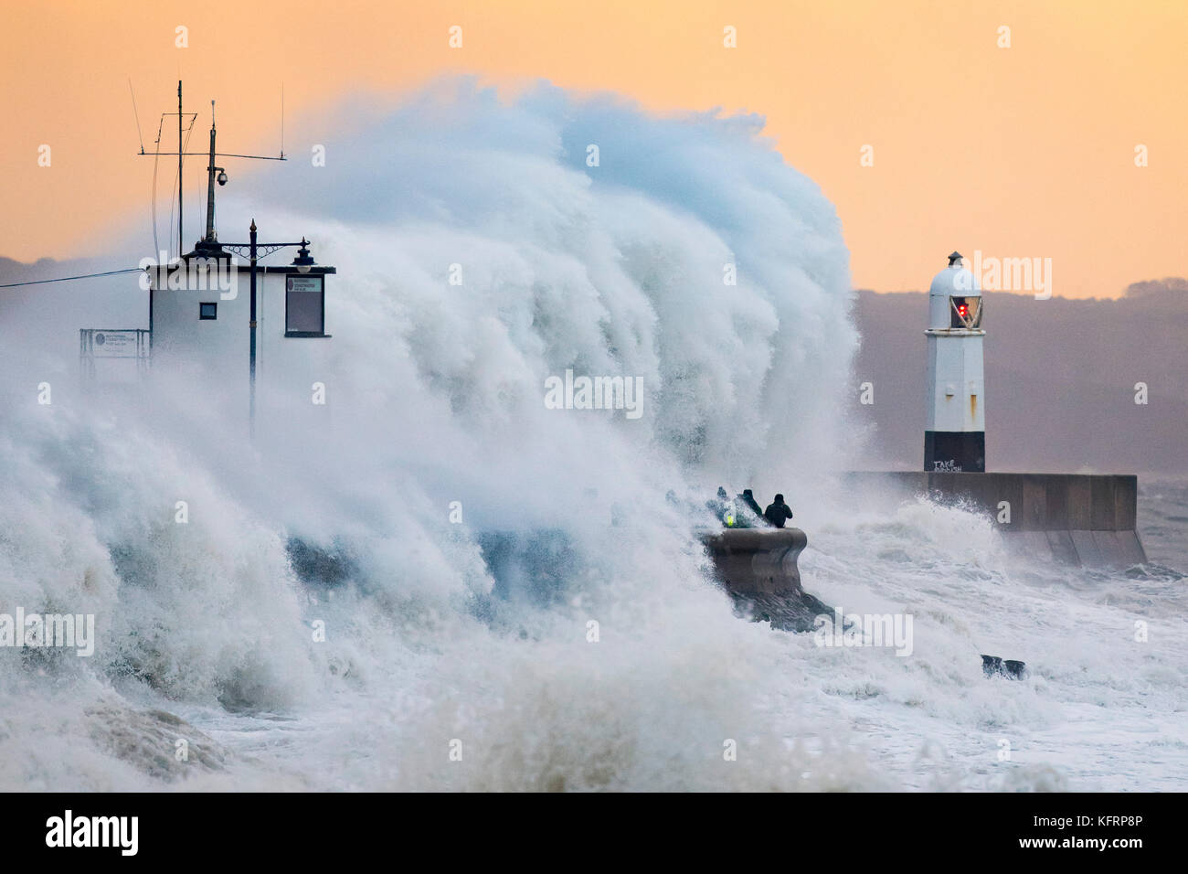 Wellen gegen die Hafenmauer während Sturm Brian bei Porthcawl, South Wales. Das Met Office haben einen gelben Wetter Warnung für Wind- und ha ausgestellt Stockfoto