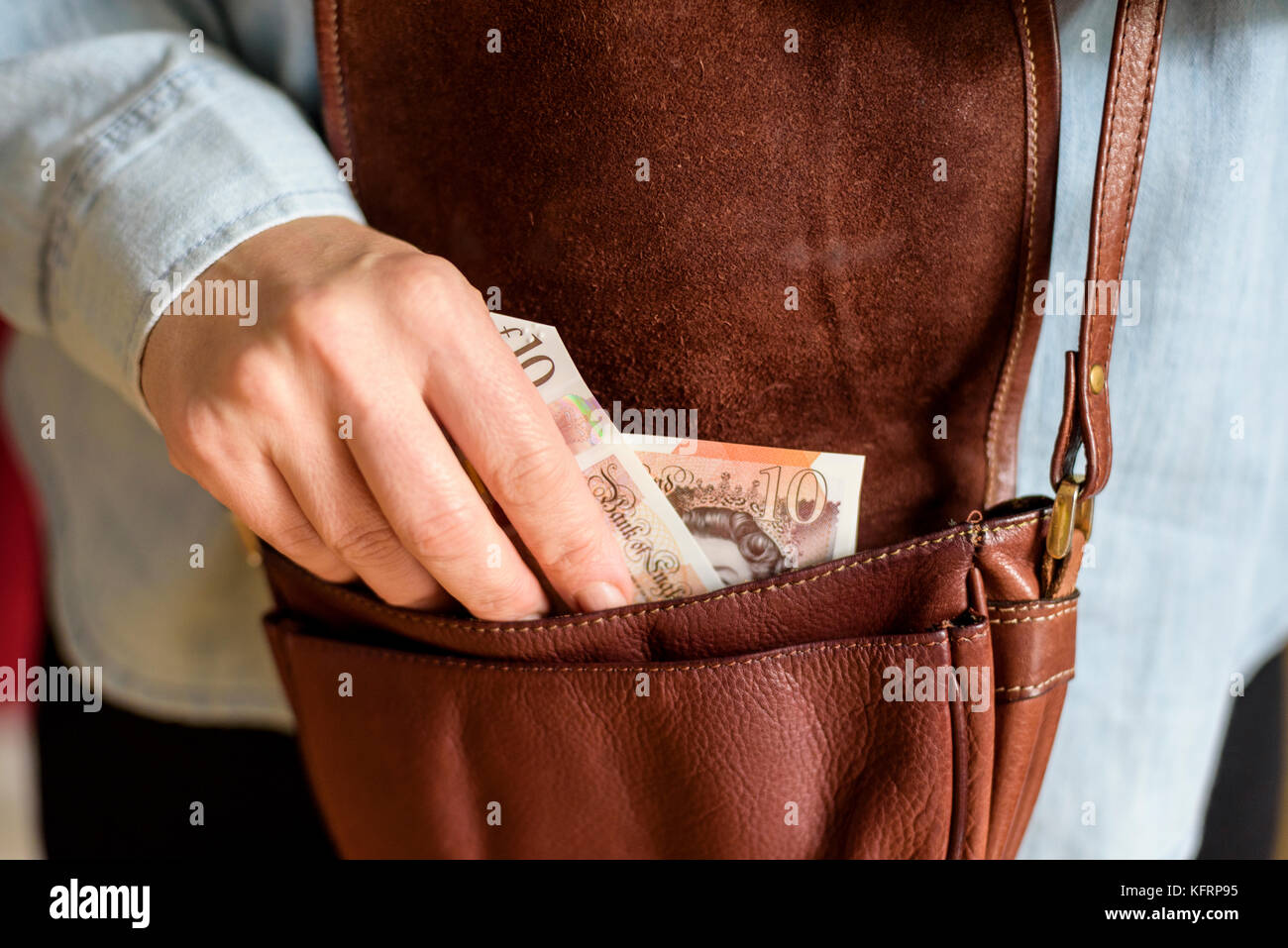 Foto einer Frau, die etwa 10 Pfund Noten aus ihrem Geldbeutel. Auf der Hand schließen und das Geld. Stockfoto