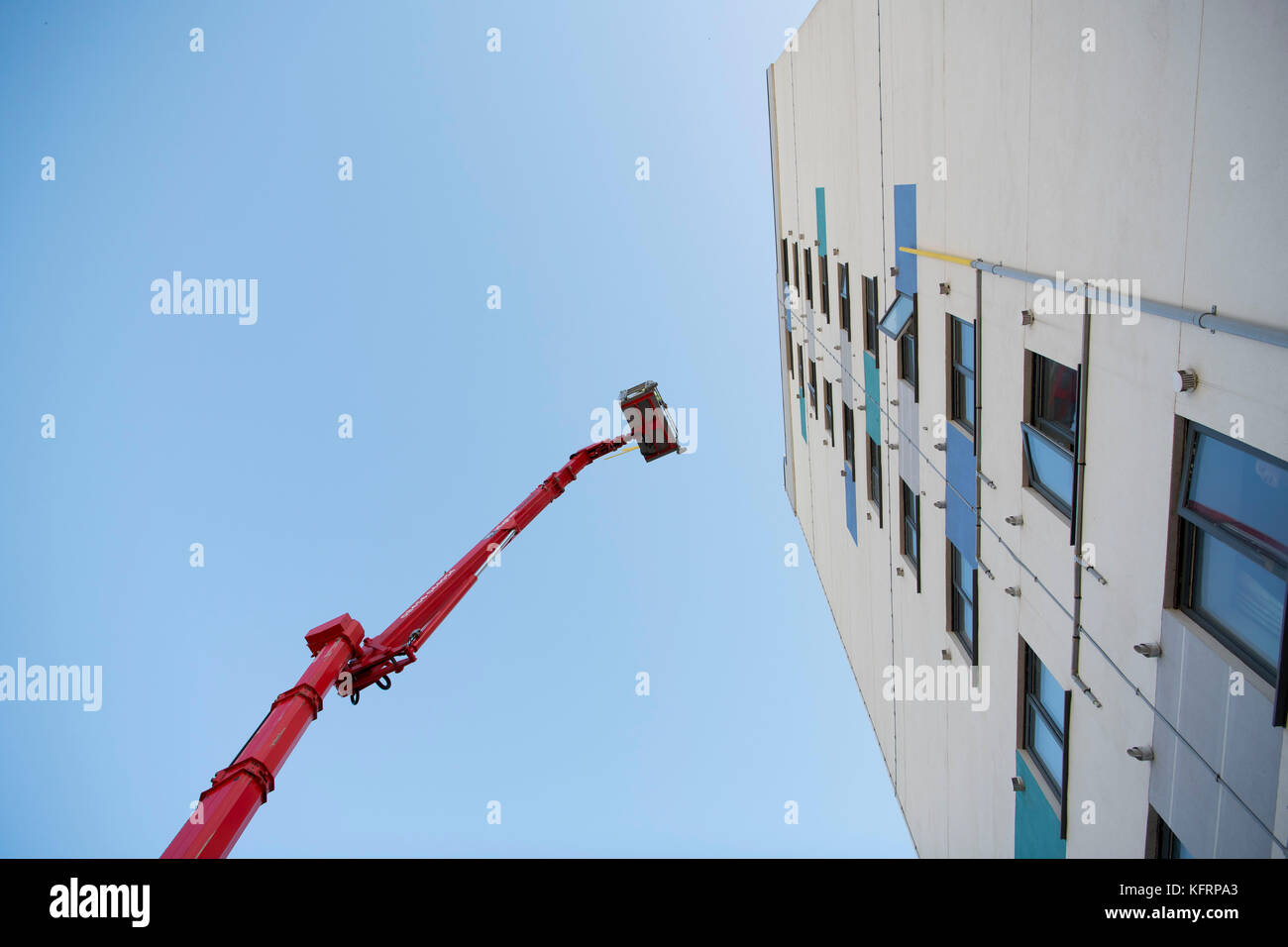 Cherry Picker erhöhten Lift neben einem Hochhaus von Gemeindewohnungen für Wartungsarbeiten in Wales, Großbritannien. Stockfoto
