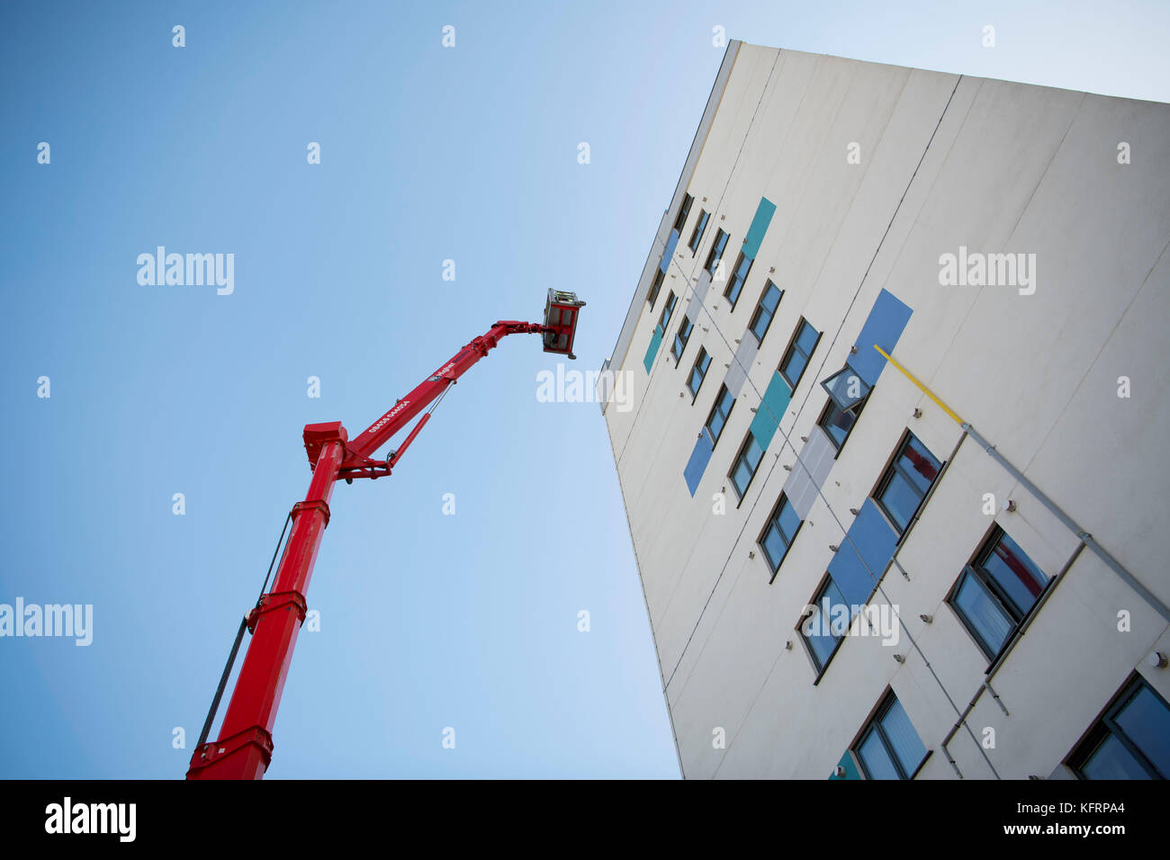 Cherry Picker erhöhten Lift neben einem Hochhaus von Gemeindewohnungen für Wartungsarbeiten in Wales, Großbritannien. Stockfoto