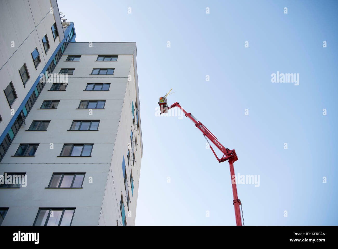 Cherry Picker erhöhten Lift neben einem Hochhaus von Gemeindewohnungen für Wartungsarbeiten in Wales, Großbritannien. Stockfoto