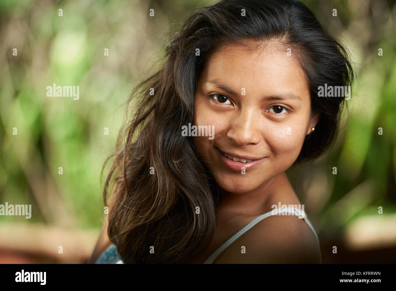 Lächelnd brünette Frau close-up Portrait auf natürliche verschwommenen Hintergrund Stockfoto