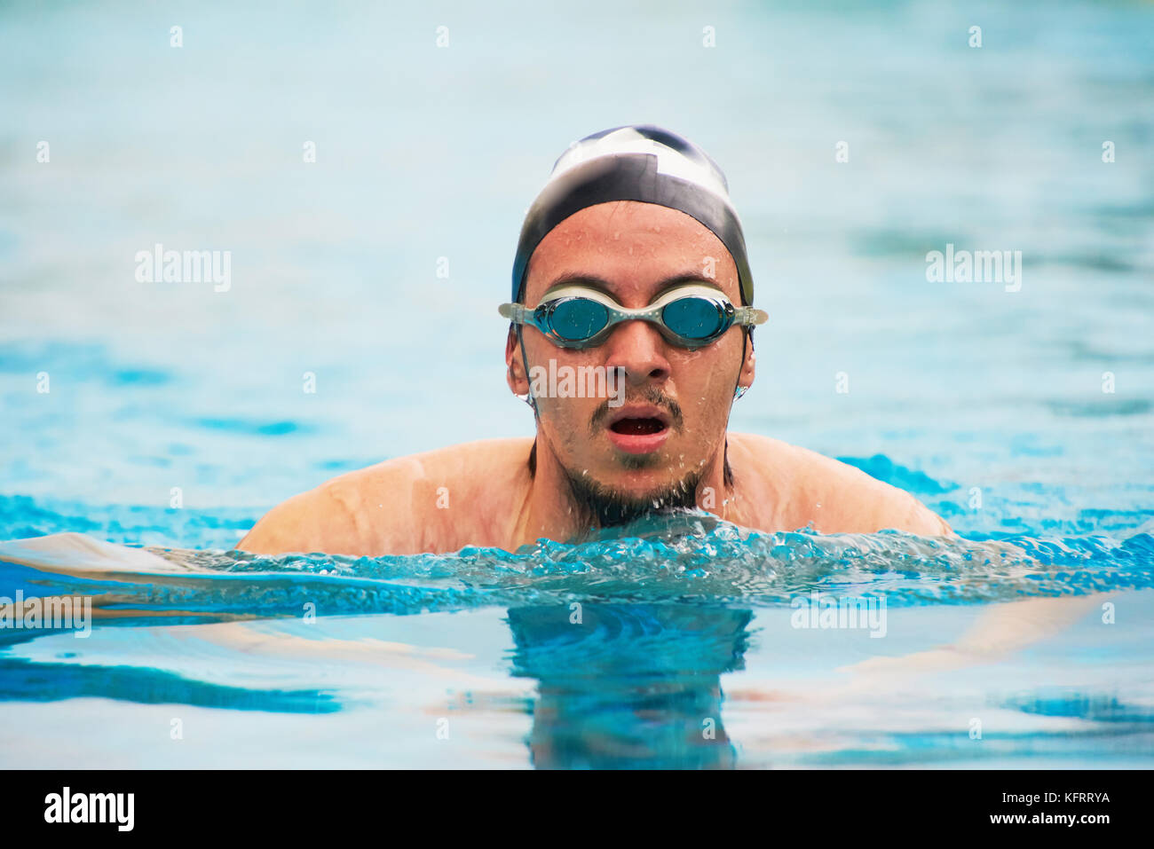 Mann in Schutzbrille schwimmen im Pool. Sportlich Mann tun schwimmen Übung Stockfoto