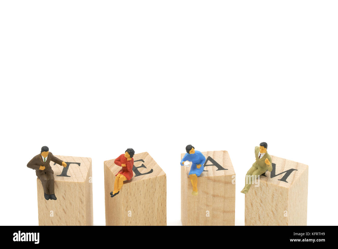 Miniatur 4 Leute sitzen auf Holz Wort Team arbeiten als Hintergrund Business Konzept mit kopieren. Stockfoto