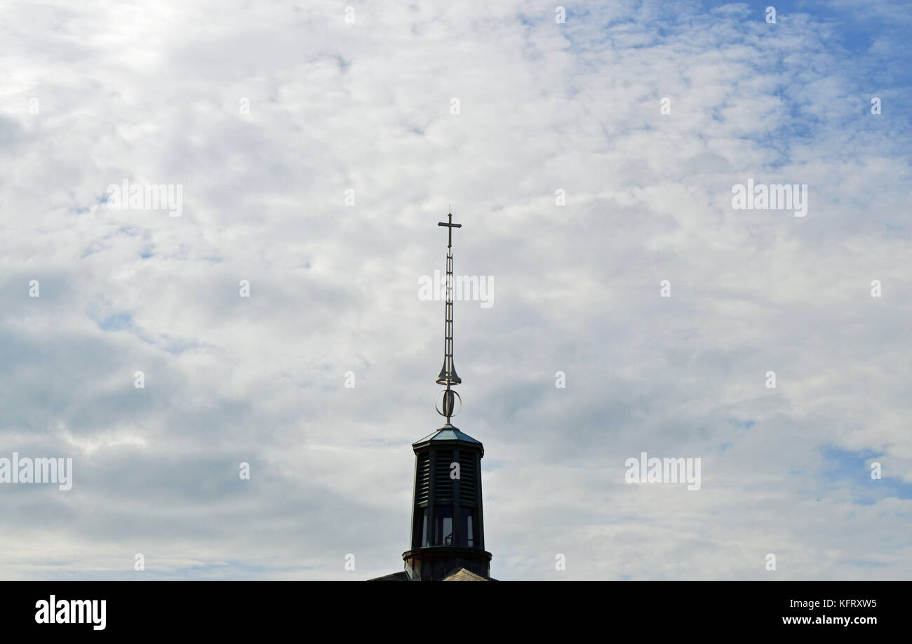 Christlichen Hintergrund Foto von einem hohen Turm auf einer Kathedrale mit einem Kreuz auf einer teilweise sonnigen Tag mit leichten Wolken im Hintergrund. Stockfoto