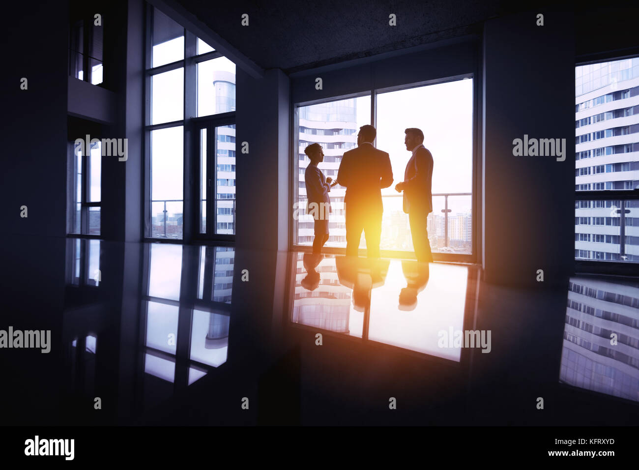 Gruppe von drei Silhouetten Unternehmer diskutieren im Büro in der Nähe von grossen Fenster. Business Konzept Stockfoto