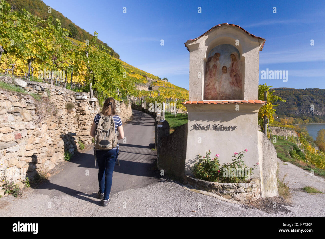 Ein Wanderer geht hinter einem marterl auf einem beliebten Wanderweg in der Nähe von Weißenkirchen in der Wachau, Niederösterreich Stockfoto