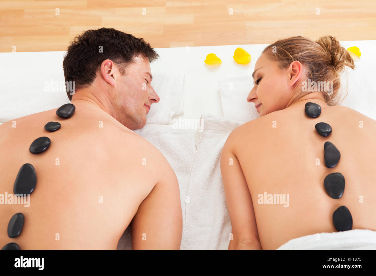 Paar genießt eine hot-Stone massage in einem Spa aufgeheizten Steinen entlang der Wirbelsäule platziert, die Muskeln entspannen Stockfoto