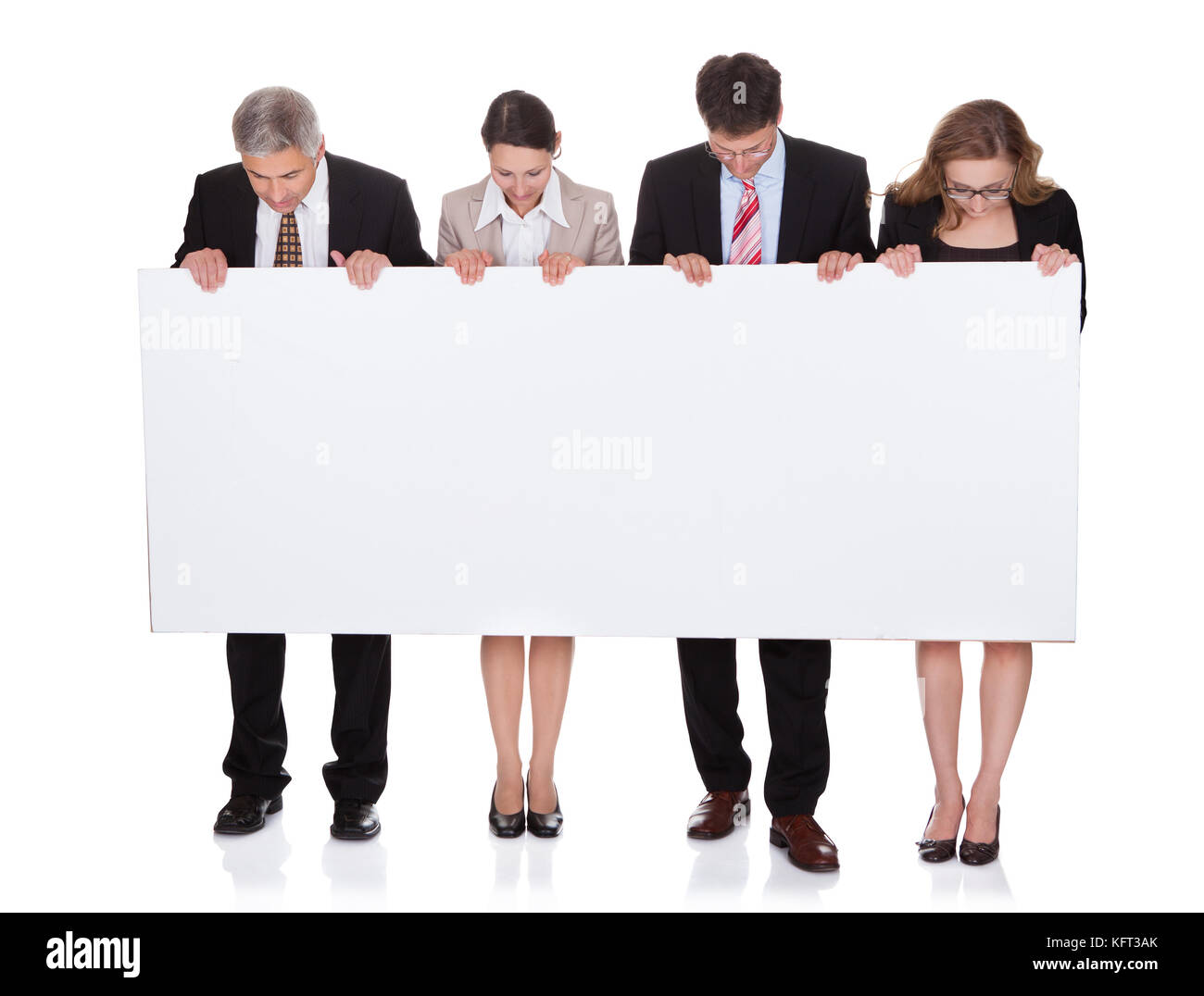 Vier verschiedene professionelle Geschäftsleute halten ein leeres Banner oder horizontale Zeichen für Ihren Text oder Ihre Anzeige isoliert auf weiss Stockfoto