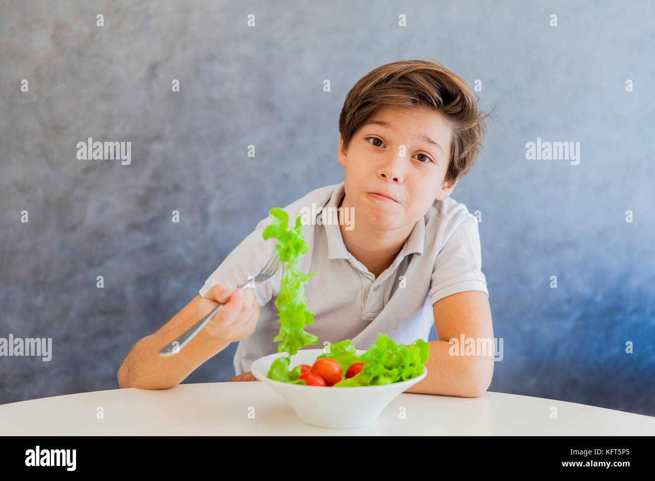 Cute teen Boy nicht gerne Salat Stockfoto