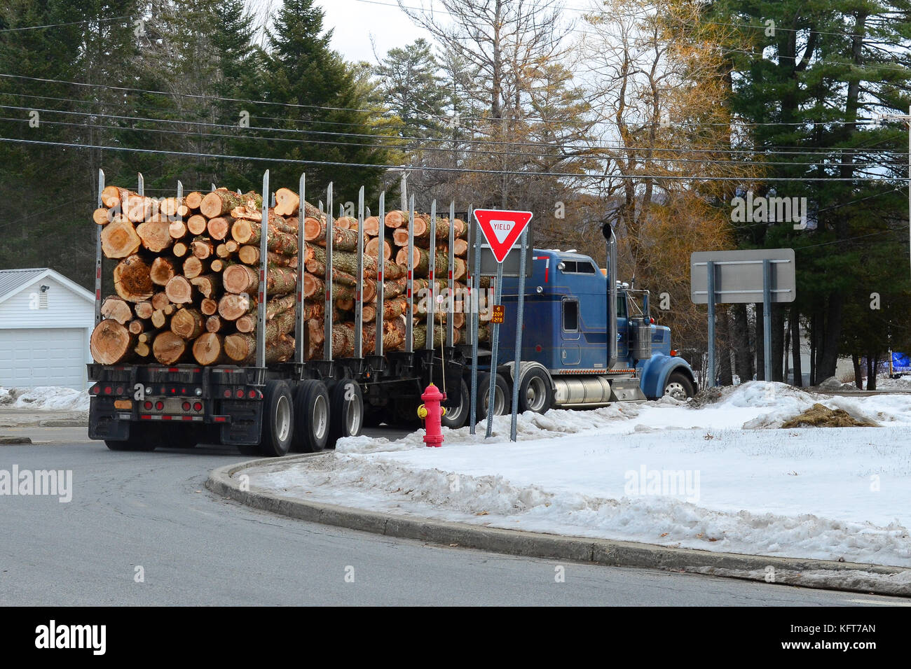 Traktoren Anhänger Lkw mit Logs um eine Ecke in der Spekulant, NY, USA in den Adirondack Mountains fahren geladen. Stockfoto