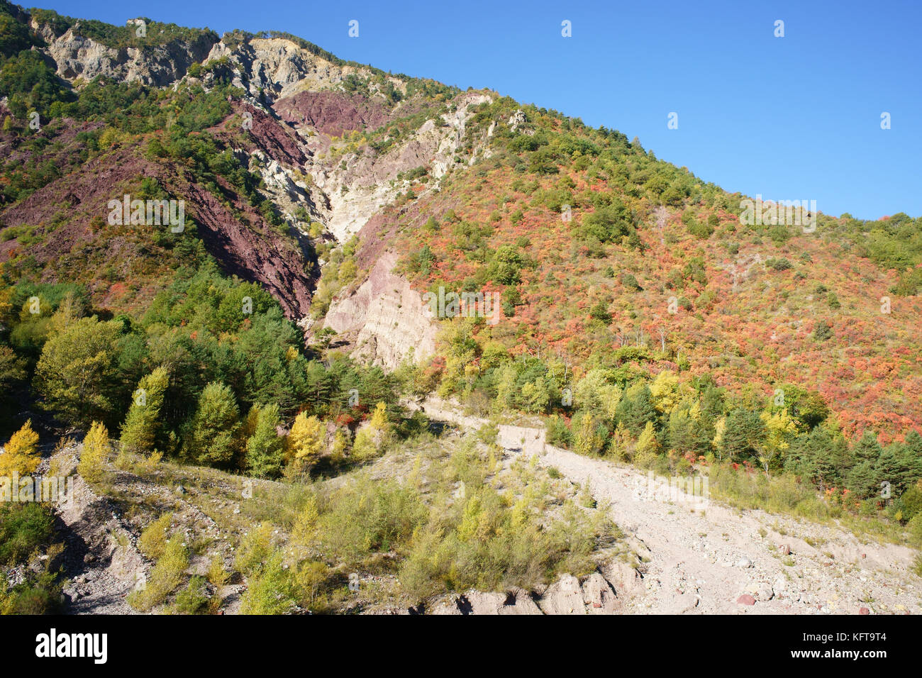 Herbstliche Farben und tief erodierte Berghänge im Tinée Valley. Saint-Sauveur-sur-Tinée, Hinterland der französischen Riviera, Alpes-Maritimes, Frankreich. Stockfoto