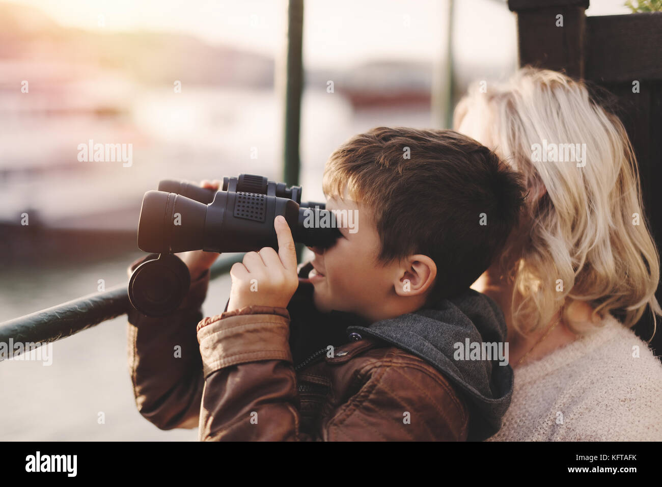 Glücklichen kleinen kaukasischen Jungen beobachten, den Blick, für die Suche, durch ein Fernglas mit Mutter Stockfoto