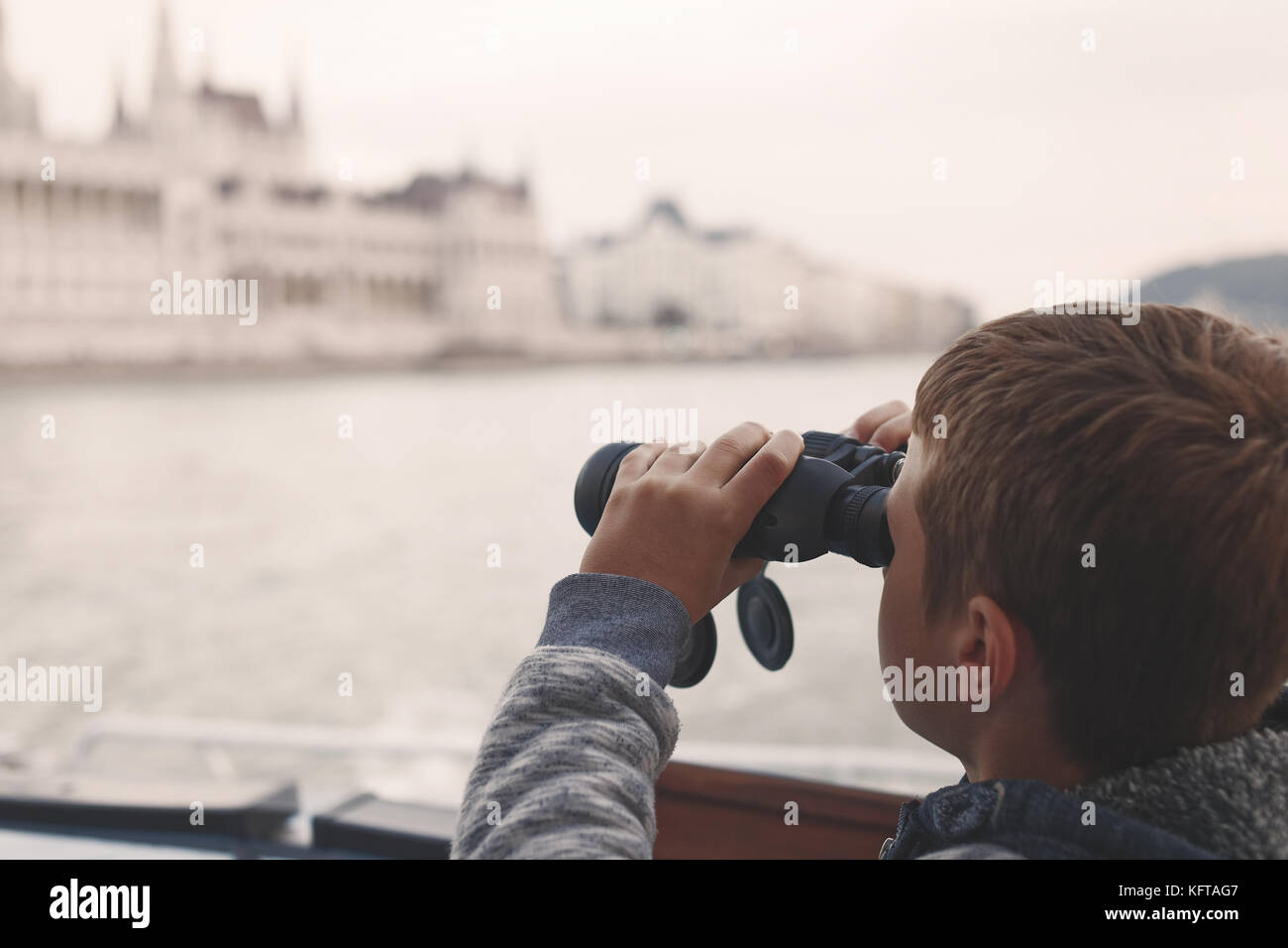 Kleine Jungen suchen, entdecken, erforschen die Stadt durch ein Fernglas auf Kreuzfahrt tour Stockfoto