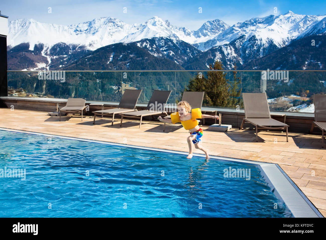 Kleine Kinder spielen im Außenpool des Luxus Alpine Resort in den ... Kleine Kinder spielen im Außenpool des Luxus Alpine Resort in den ...