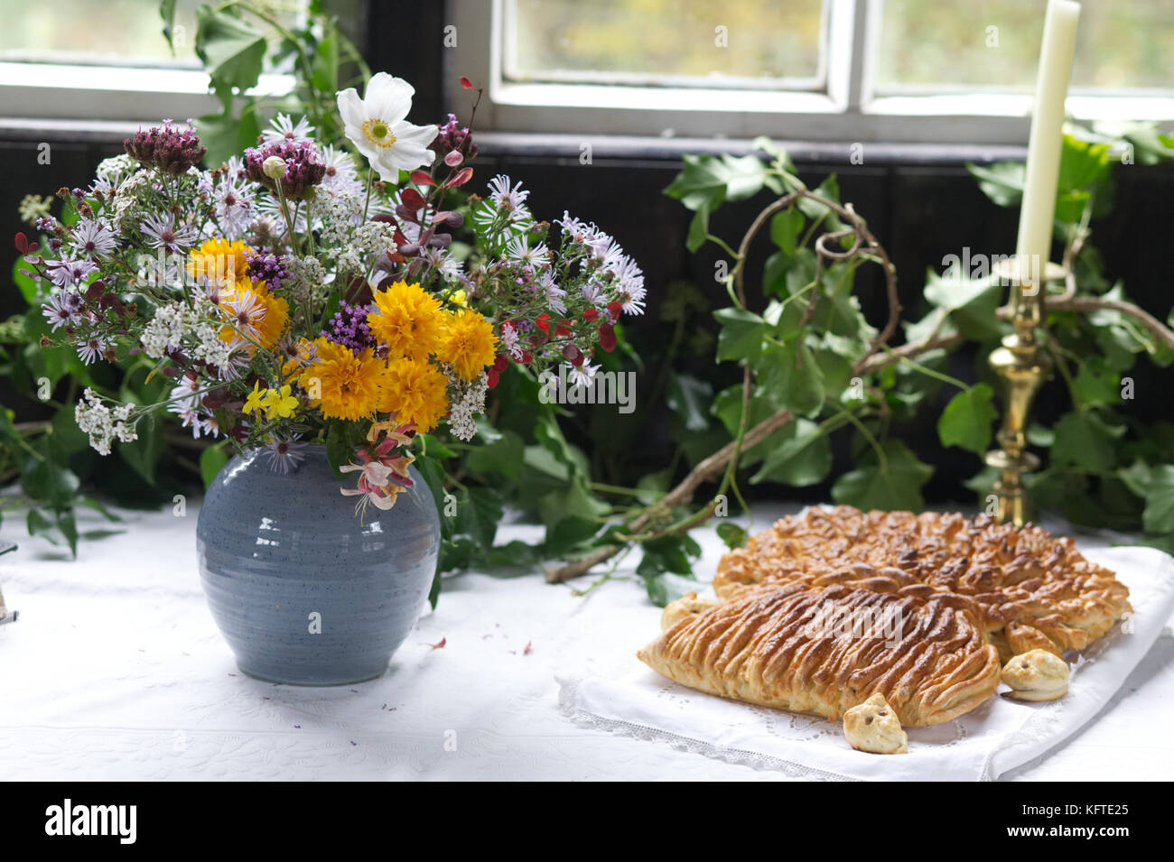Vase mit Blumen und frisch gebackenem Brot Stockfoto
