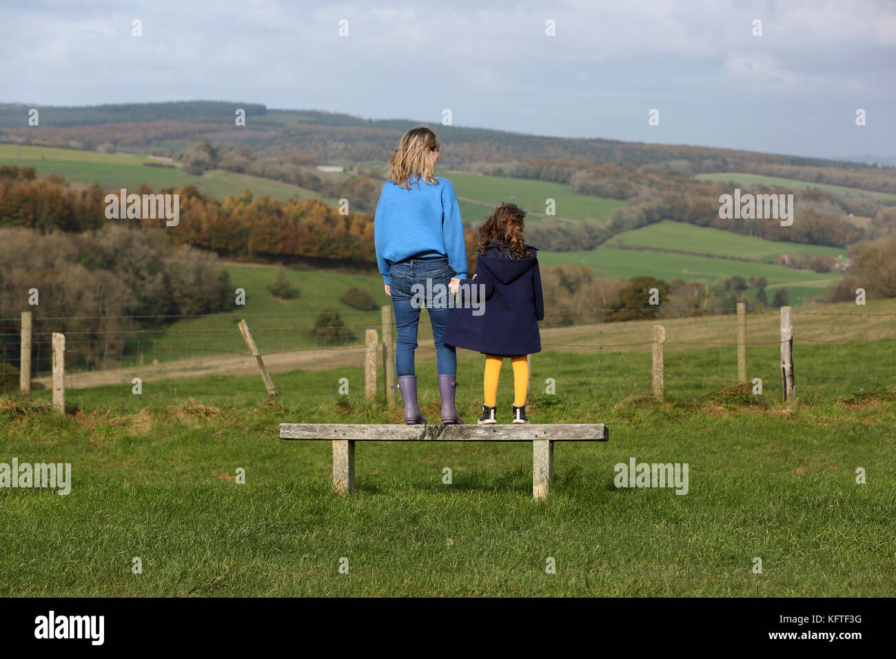 Eine Mutter und ihre zwei Kinder im Bild bei einem Picknick und ein Sandwich auf der South Downs in der Nähe von Goodwood, West Sussex, UK. Stockfoto