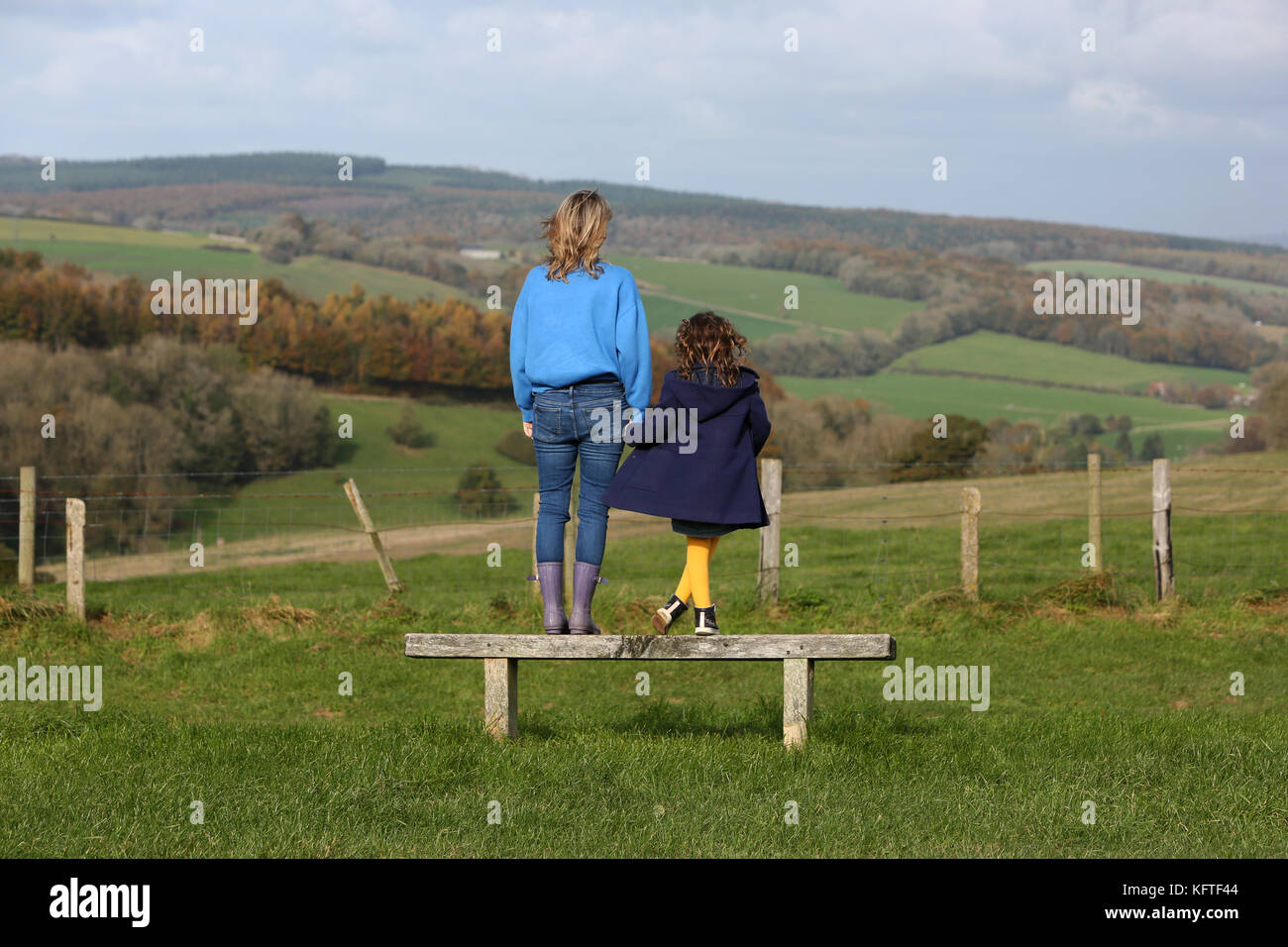 Eine Mutter und ihre zwei Kinder im Bild bei einem Picknick und ein Sandwich auf der South Downs in der Nähe von Goodwood, West Sussex, UK. Stockfoto