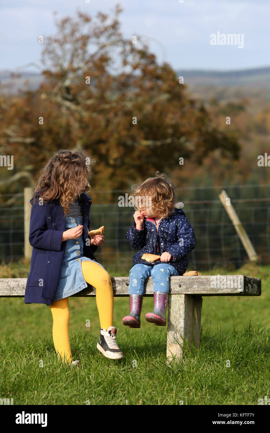 Eine Mutter und ihre zwei Kinder im Bild bei einem Picknick und ein Sandwich auf der South Downs in der Nähe von Goodwood, West Sussex, UK. Stockfoto