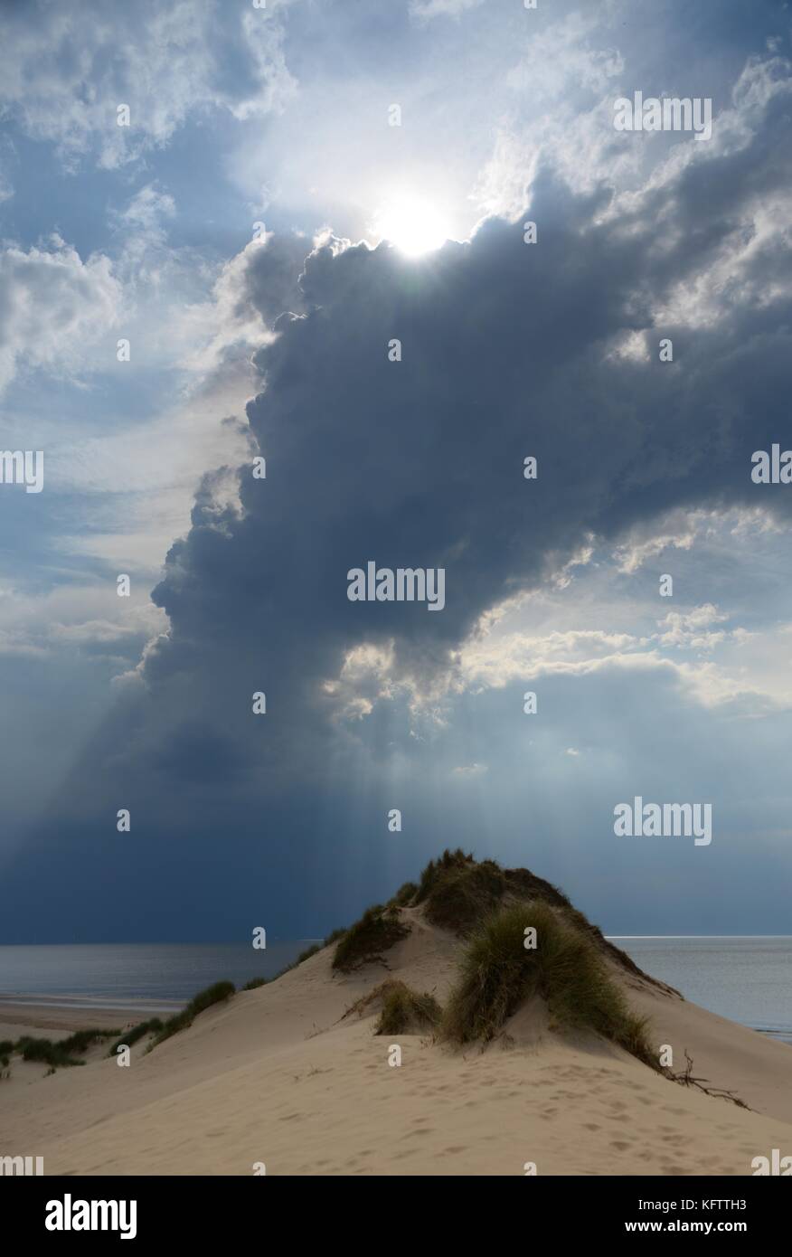 Inspirierende Sonne aus Wolken über Sand dune brechen Stockfoto