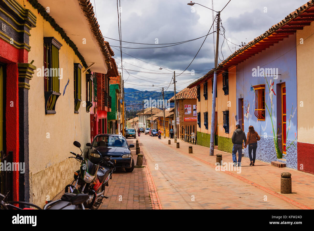 Kolumbien, Südamerika - Straße, die von der Hauptplatz in der Cundinamarca Department Town von Nemocón, in hellem Sonnenlicht. Farbenfrohe Gebäude. Stockfoto Kolumbien, Südamerika - Straße, die von der Hauptplatz in der Cundinamarca Department Town von Nemocón, in hellem Sonnenlicht. Farbenfrohe Gebäude. Stockfoto