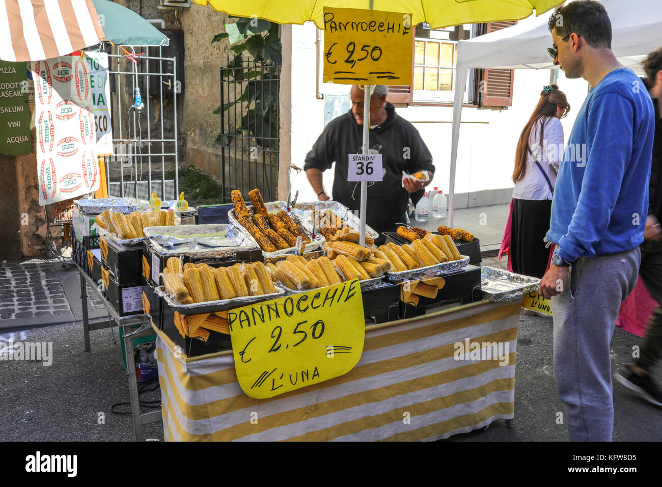 Manziana, Latium, Italien - 14. Oktober 2017: Der Mann, der den Kauf von gegrilltem Mais von street vendor am Kastanienfest. Stockfoto