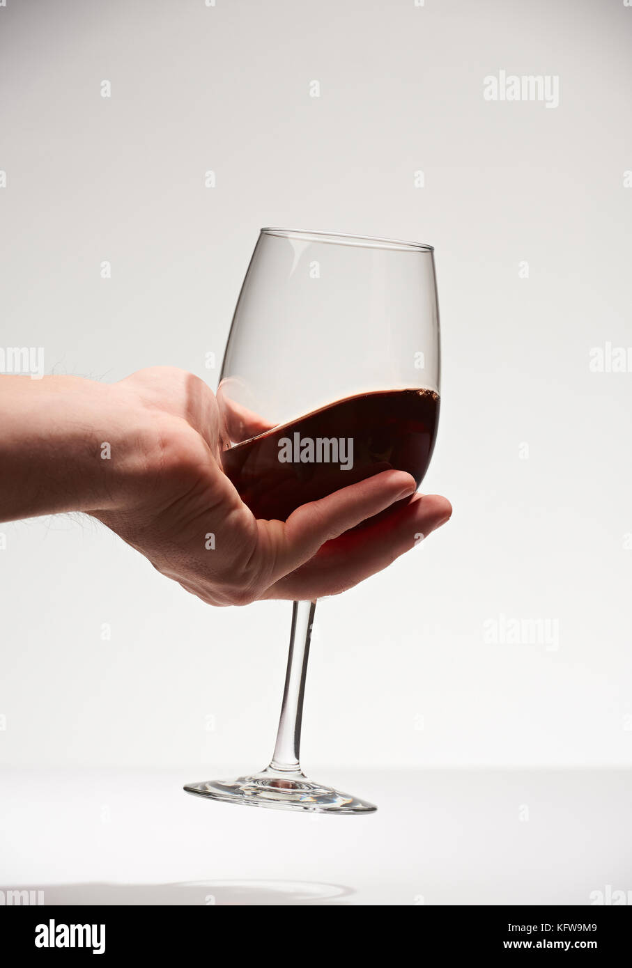 Rotwein Glas in der Hand palm Closeup auf weißem Hintergrund. Rotwein trinken Stockfoto