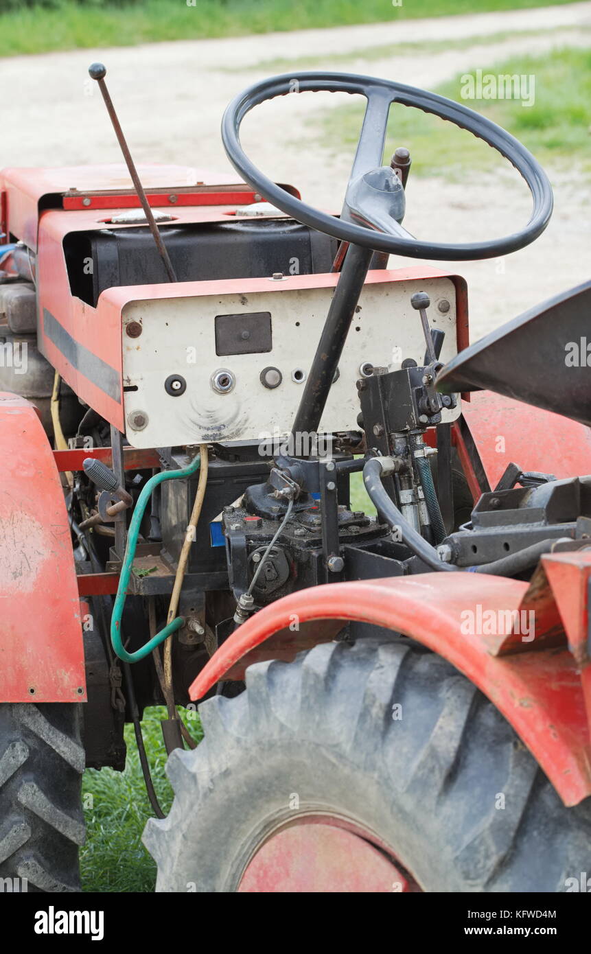Red schmutzige alte kleiner traktor Nahaufnahme auf dem Feldweg Stockfoto