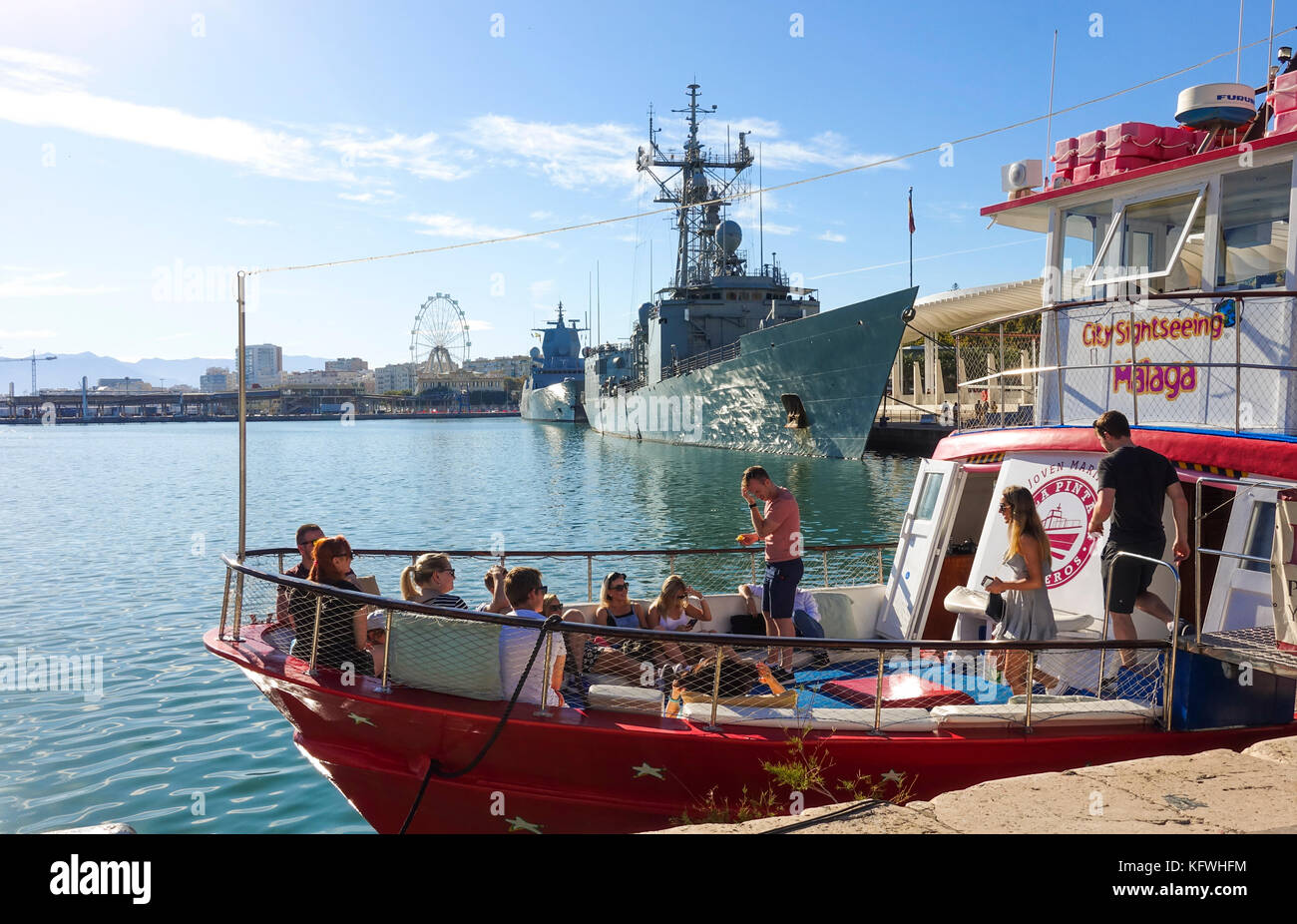 Touristenboot Ausfahrt aus dem Hafen von Malaga, zwei Kriegsschiffe im Hintergrund, Andalusien, Spanien Stockfoto