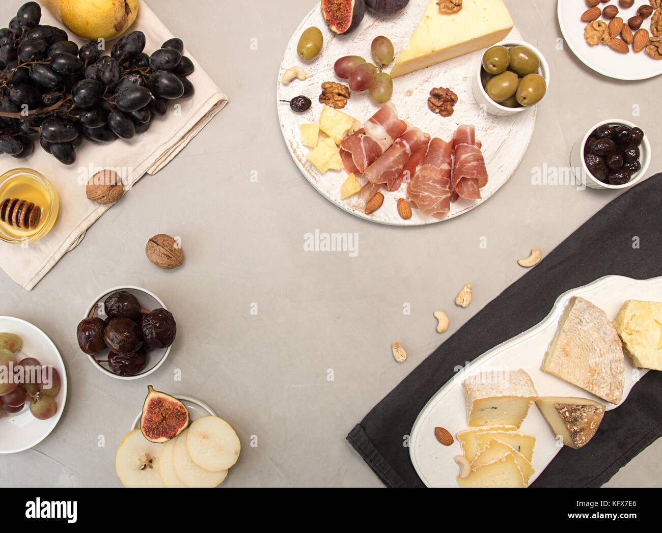 Die Zusammensetzung von Lebensmitteln Käseplatte mit Käse, Aufschnitt, verschiedene Früchte und Nüsse. Overhead von stücksatz verschimmelten Käse, Schinken, eingelegten Pflaumen, bunc Stockfoto