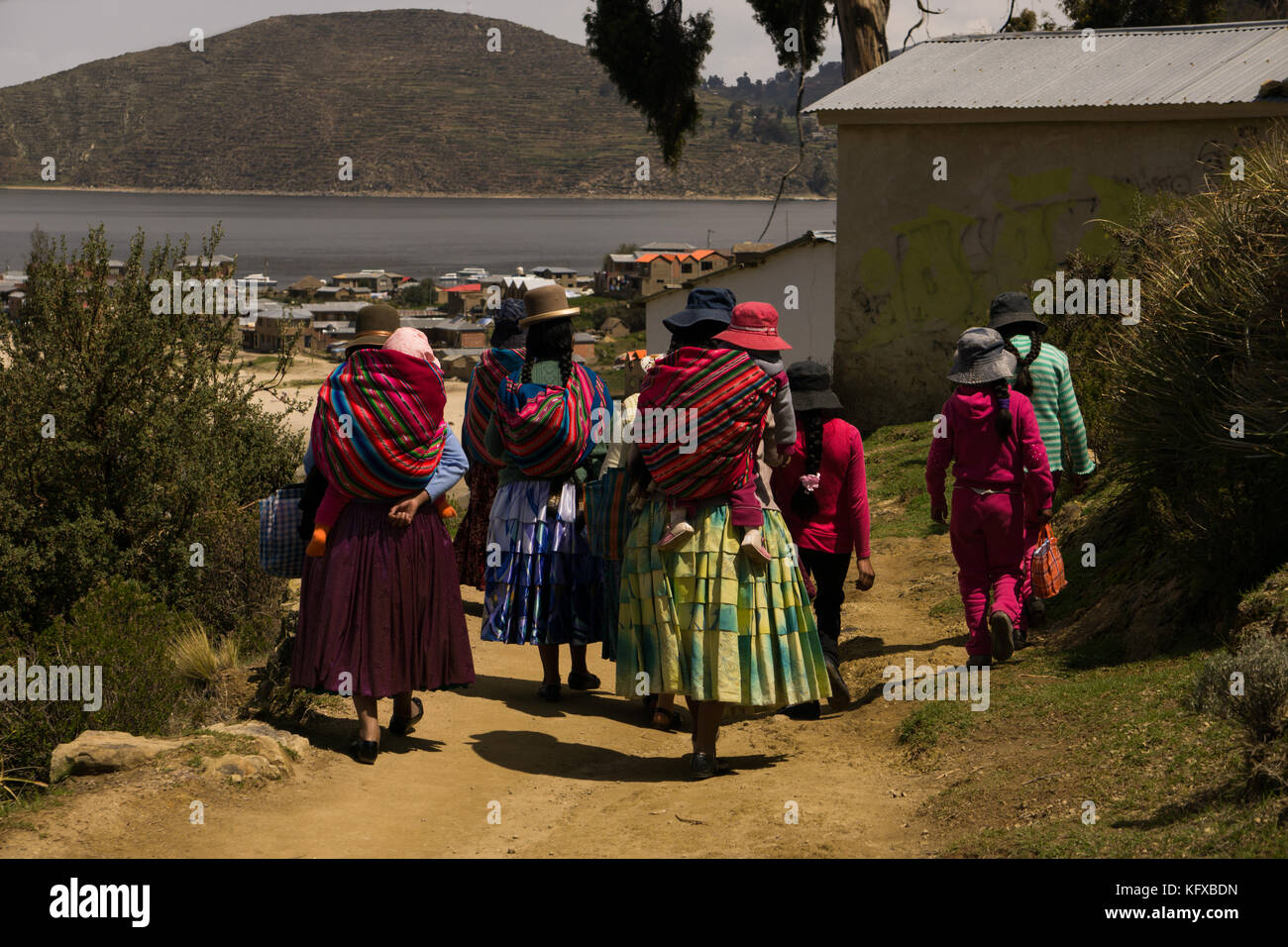 Farben von Bolivien, einer Gruppe von cholita Mütter und ihre Töchter und Babys zu Fuß durch die Pfade der Isla del Sol, Bolivien, Südamerika Stockfoto