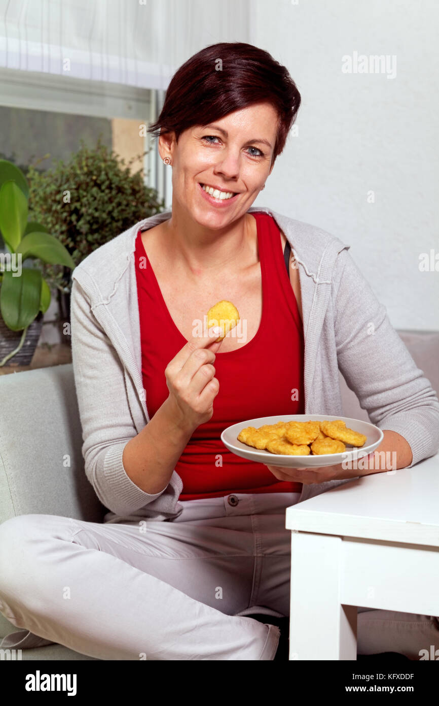 Frau essen Chicken Nuggets Stockfoto