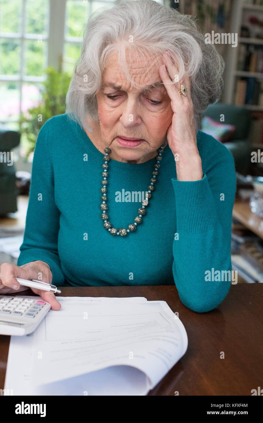 Ältere Frau, die durch Rechnungen und suchen besorgt Stockfoto