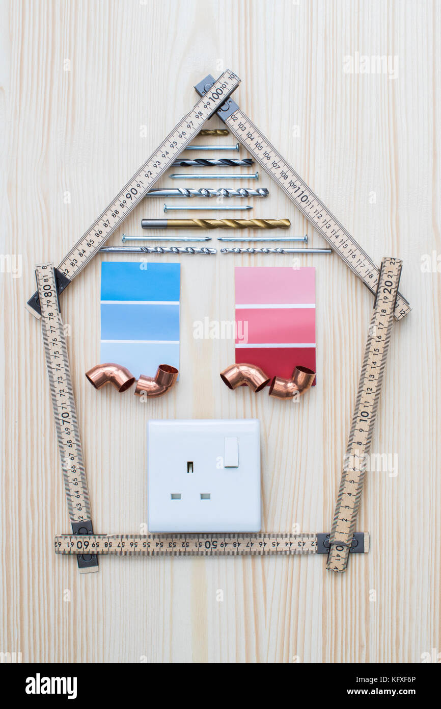 Bauteile in Form von Haus auf Holz- Hintergrund angeordnet Stockfoto