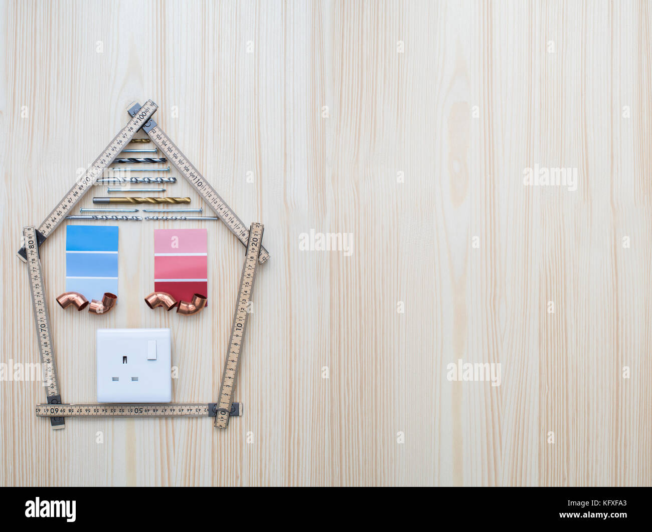 Bauteile in Form von Haus auf Holz- Hintergrund angeordnet Stockfoto