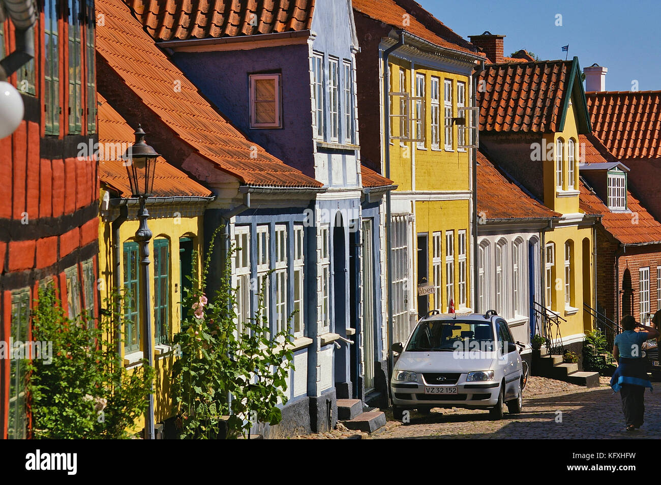 Aeroskobing, Dänemark - 4. Juli 2012 - schmale Kopfsteinpflasterstraße auf der Insel Aero mit bunten historischen Wohngebäuden, geparktem Auto, Pede Stockfoto