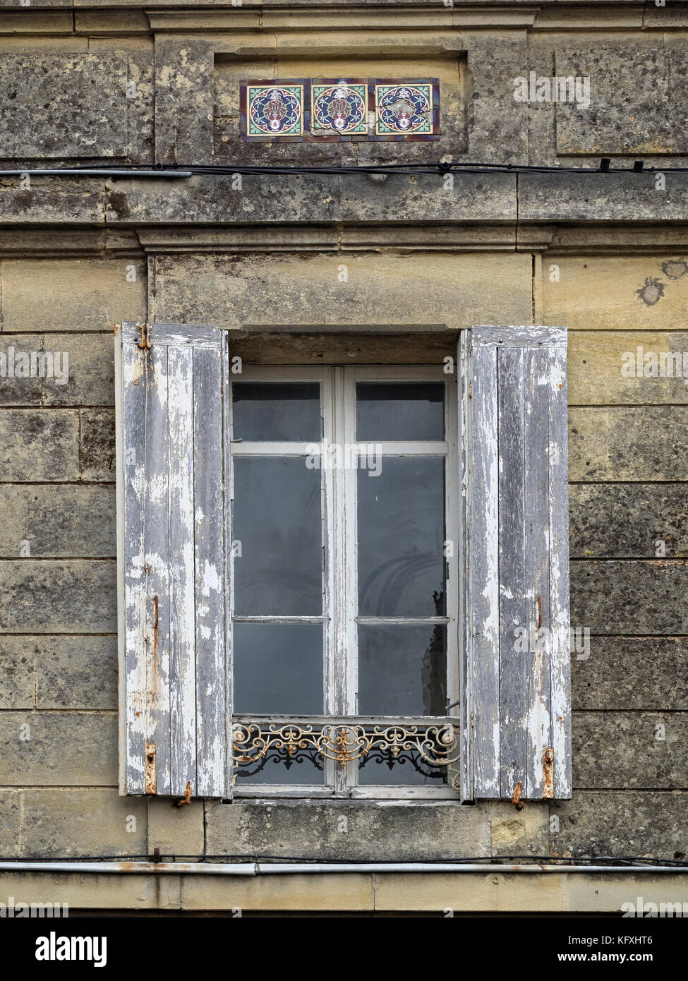 Altes verwittertes Holzfenster mit Fensterläden in Steinwand Stockfoto