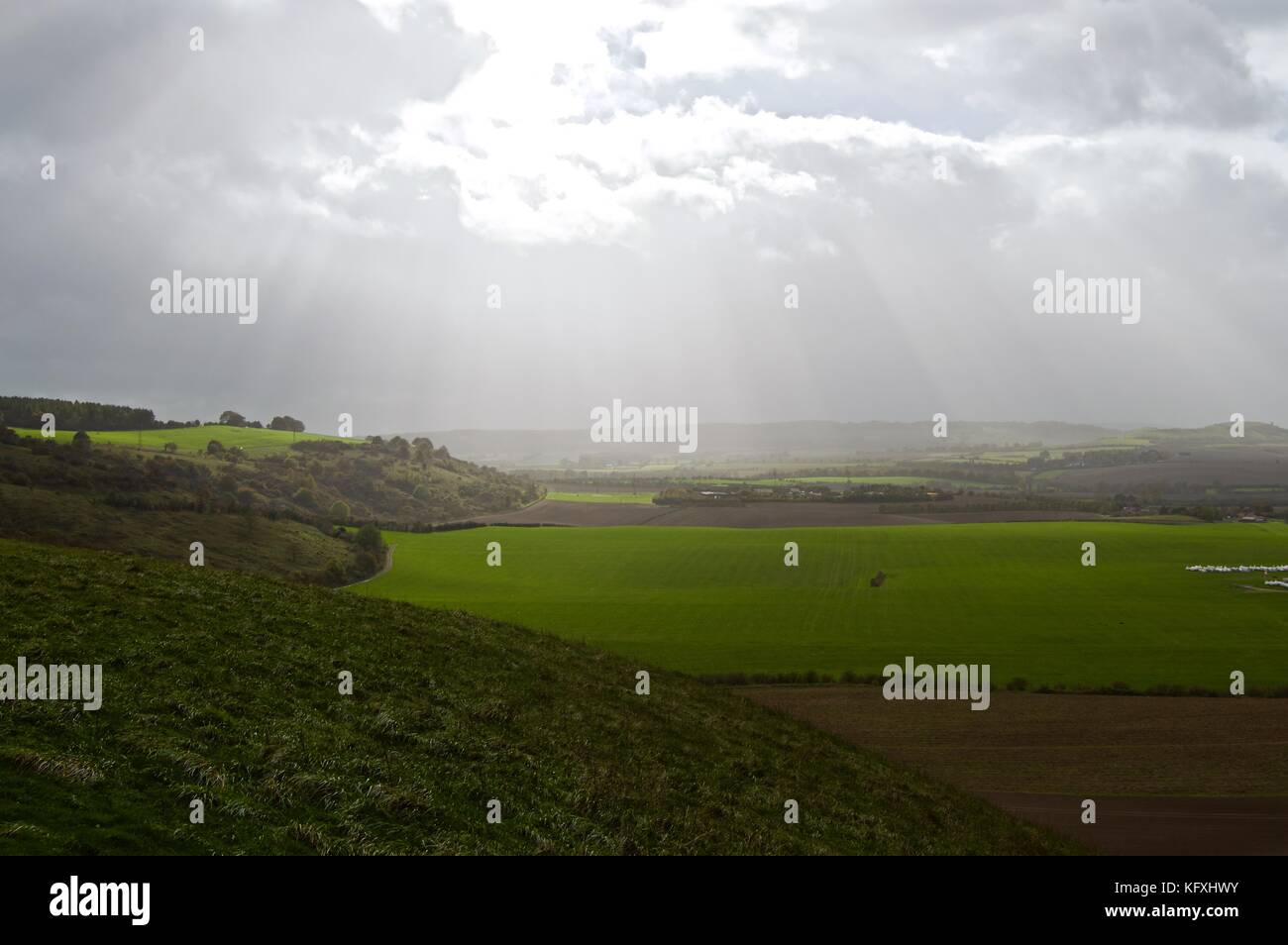 Sonne bricht durch die Wolken an einem windigen Oktobertag auf Dunstable Downs, Blick auf Felder, Bedfordshire, Großbritannien Stockfoto