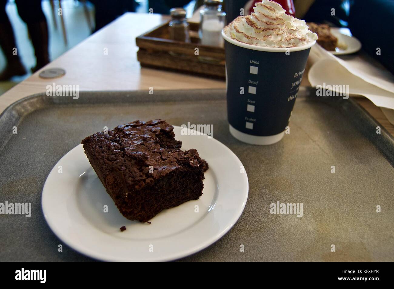 Chocolate Brownie und Papier Tasse heiße Schokolade auf einem Tablett in Dunstable Downs Cafe, Chiltern Hills Gateway Center, Bedfordshire, Großbritannien Stockfoto