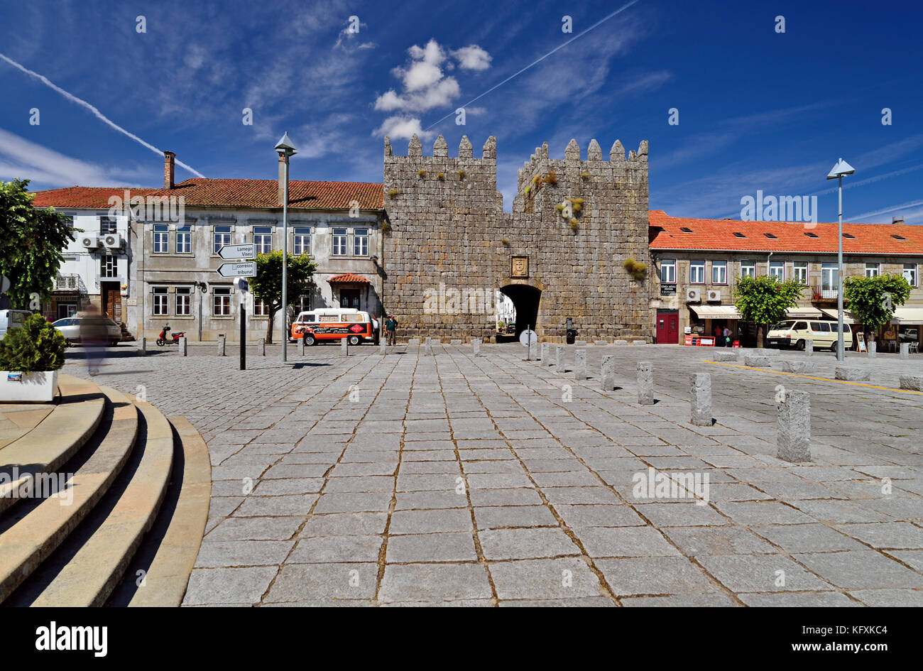 Breiter gepflasterter Platz mit mittelalterlichem Eingangstor, der zum historischen Zentrum von Trancoso führt Stockfoto