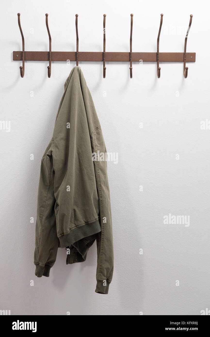 Jacke an den Haken gegen weiße Wand hängen Stockfotografie