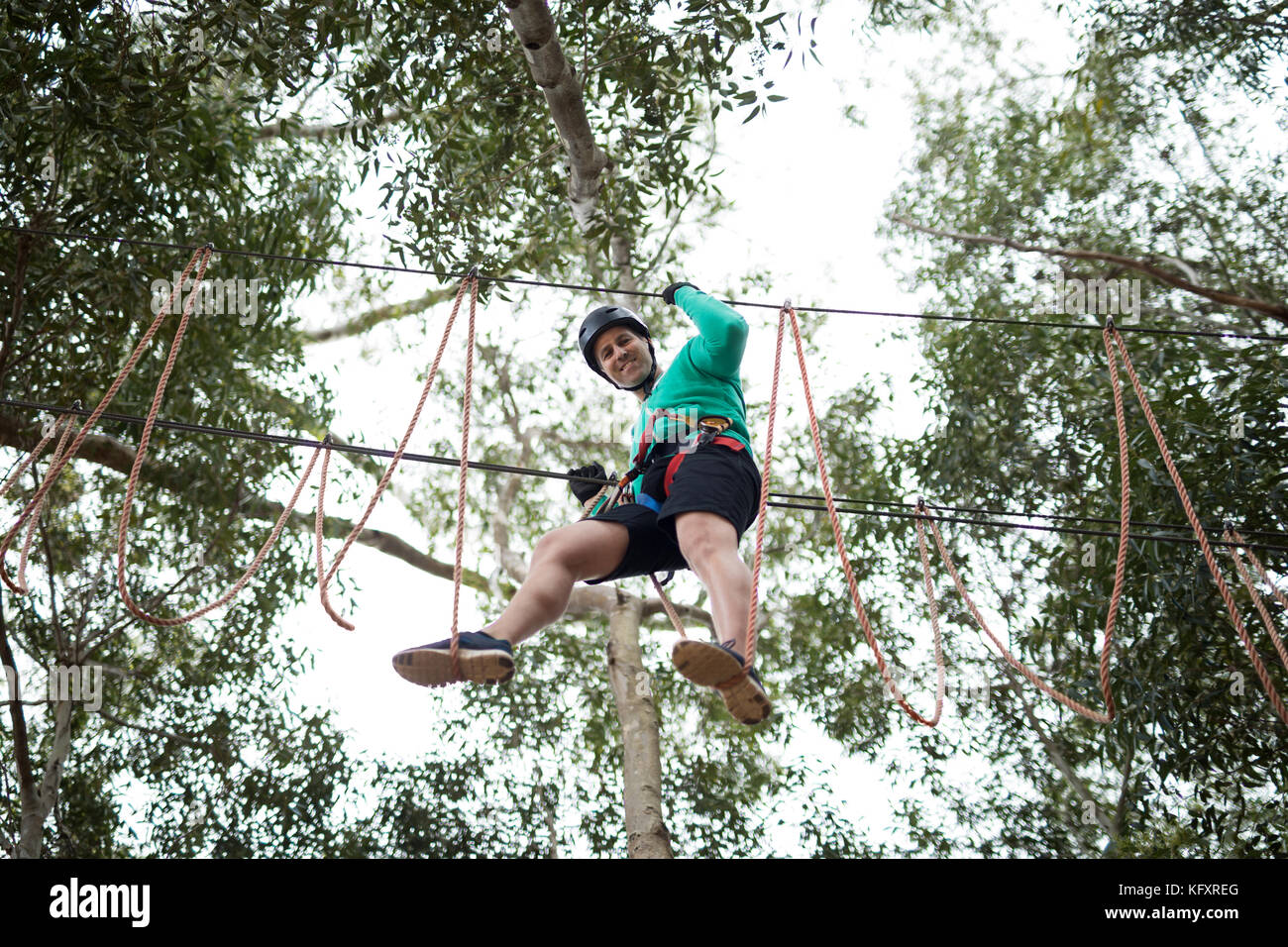 Glückliche Menschen genießen Zip Line Abenteuer in Park Stockfoto